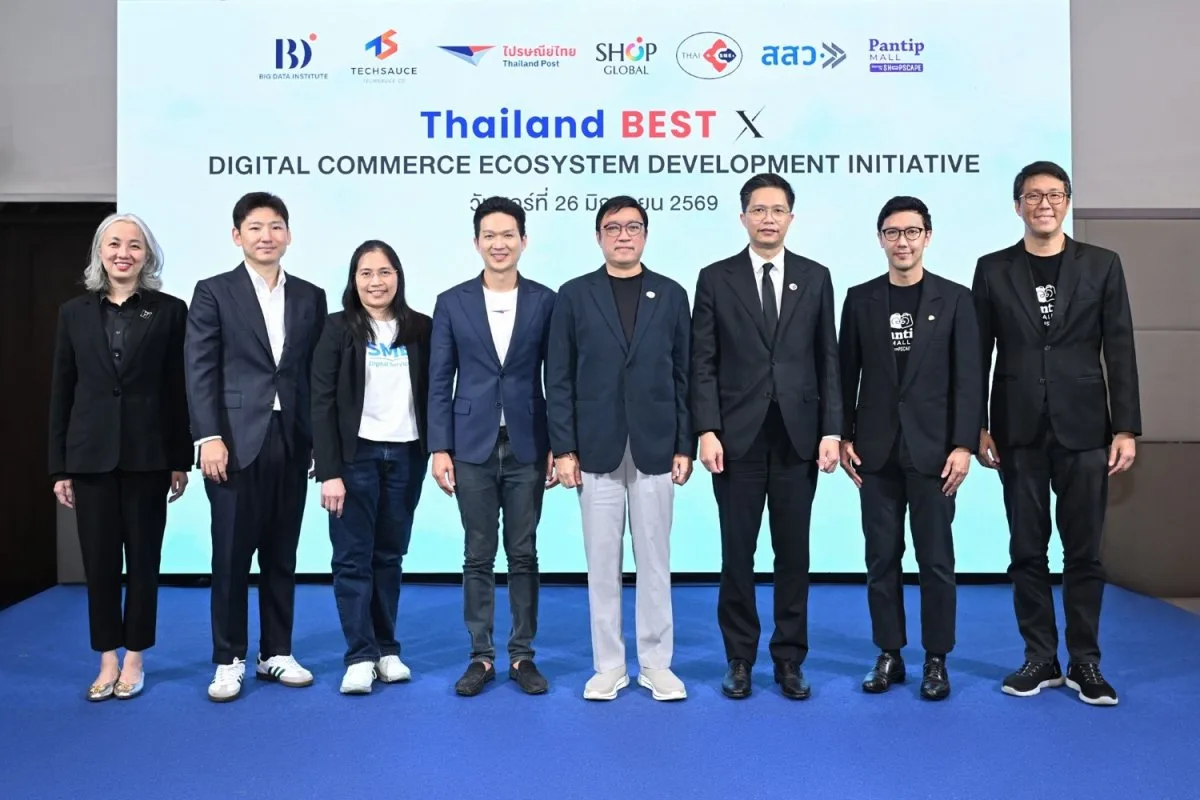 Eight executives standing in a line on the stage in front of the Thailand Best X backdrop, two of them in Pantip MALL branded jackets.